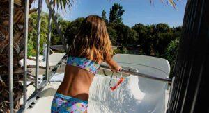 Girl at the top of a slide, holiday village water park in Corsica