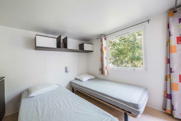 chambre avec deux lits simple dans un bungalow