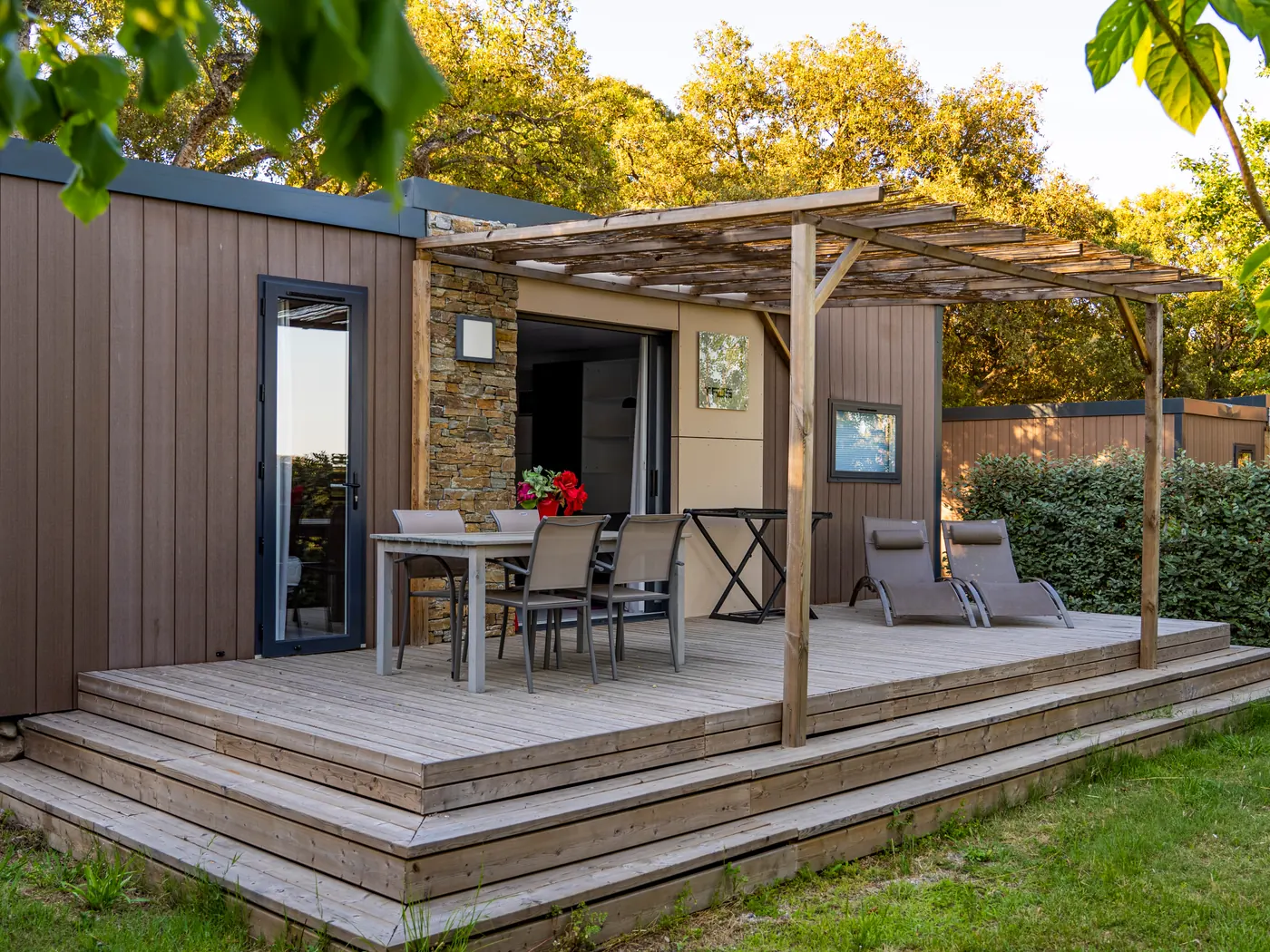 Cottage avec terrasse en bois et salon de jardin au camping Le Campoloro