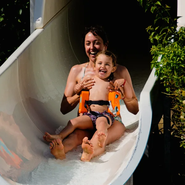 Une mère et son enfant glissent sur le toboggan aquatique