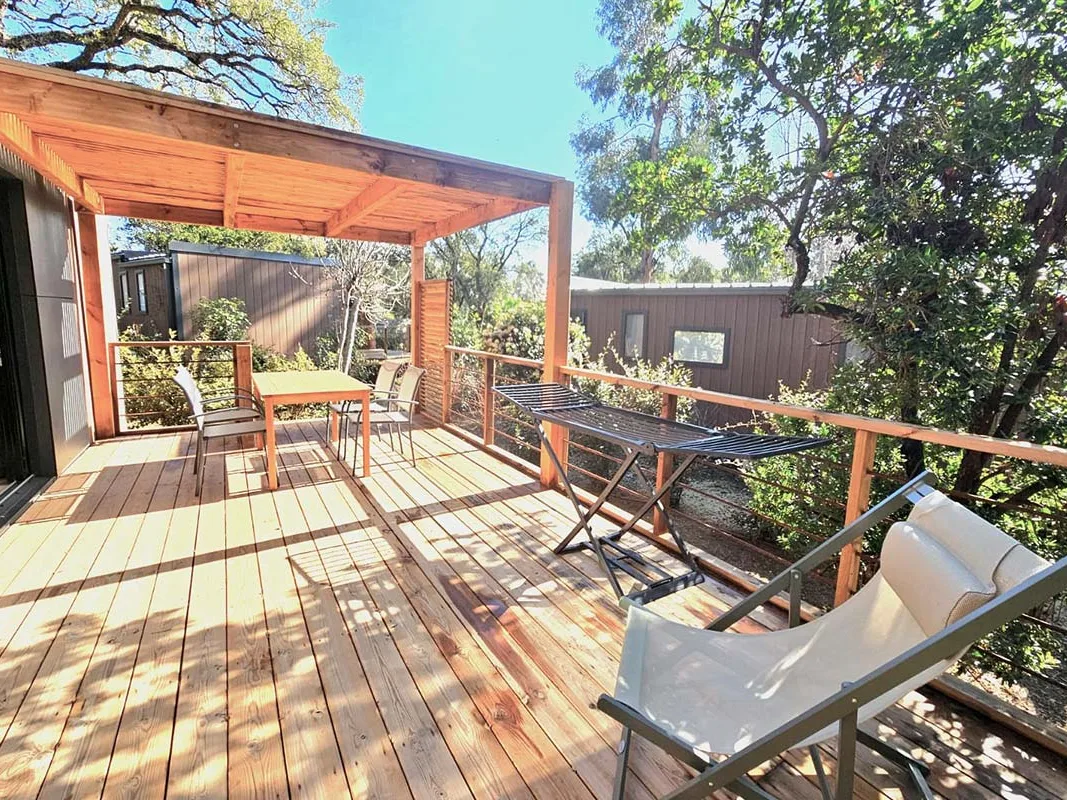 Terrasse en bois d'un cottage Taos Plus avec transat, camping Le Campoloro en Corse