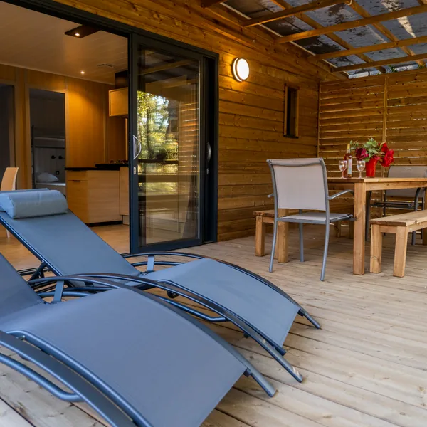 Terrasse couverte avec transats d’un cottage au camping Le Campoloro